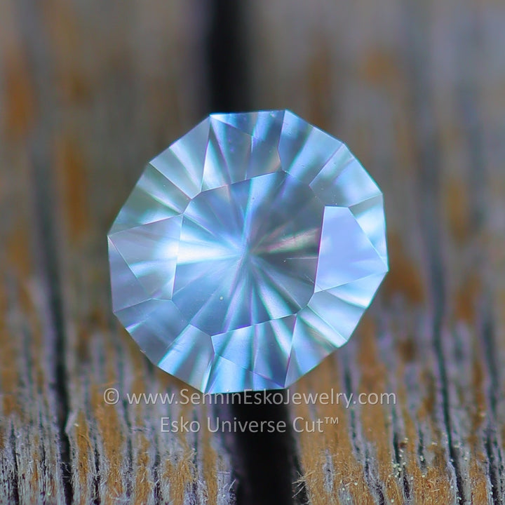 Faceted gemstone on a textured surface with 'Semin Esko Jewelry' branding.