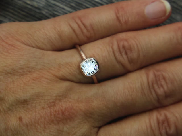 Colorless Moissanite 6x6mm Cushion Cut Bezel Solitaire Ring With A Medium/Lightweight Band