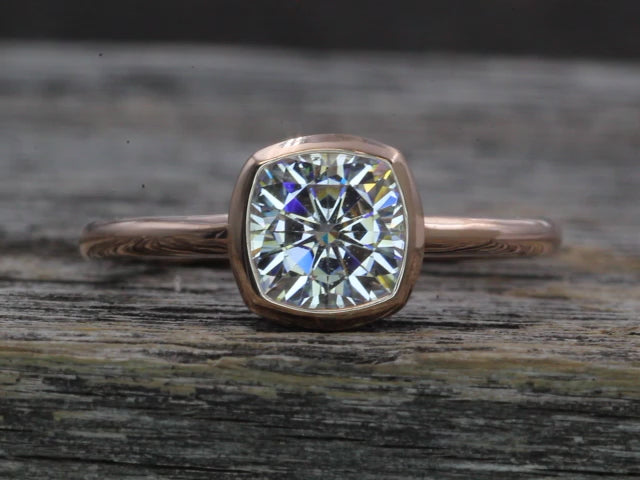 Colorless Moissanite 6x6mm Cushion Cut Bezel Solitaire Ring With A Medium/Lightweight Band